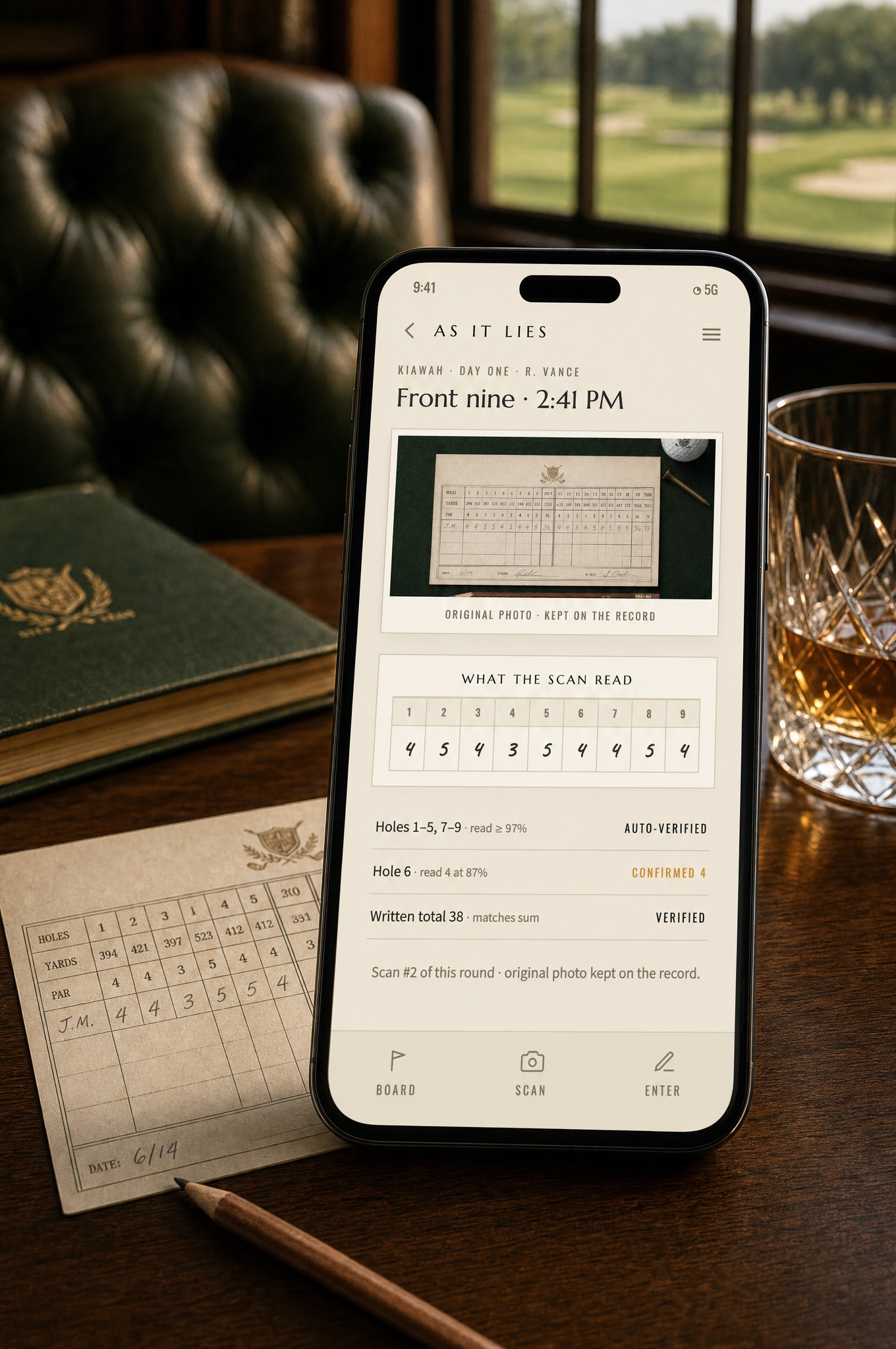 The receipt screen on a phone beside the original paper scorecard and a whiskey in the clubhouse